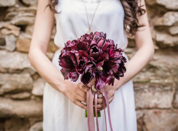 mariée en robe blanche avec un bouquet rouge